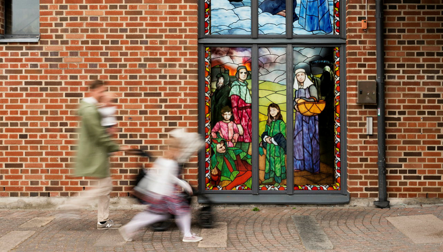 En vuxen och barn rör sig i hög fart in i en tegelbyggnad