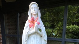 En staty av jungfru Maria med en lilja i handen