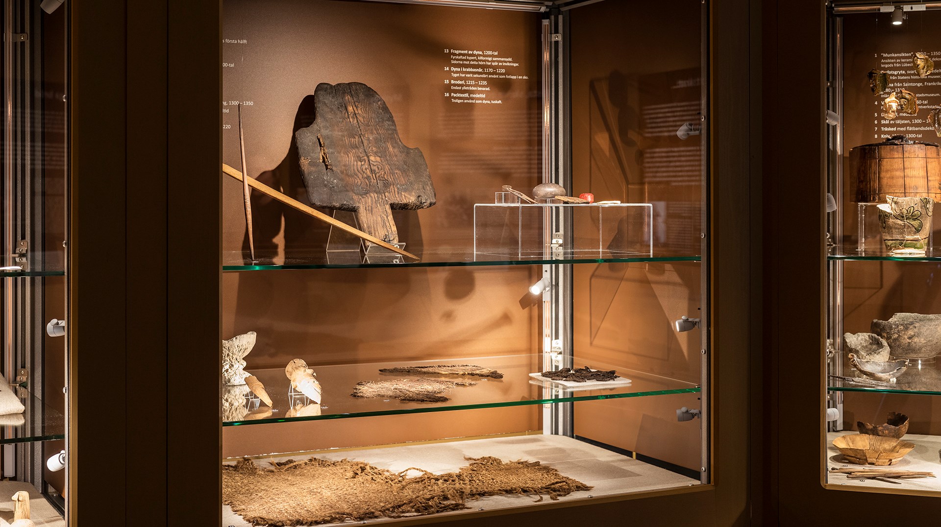 På bilden syns en monter med föremål. Färgen i montern är ljusbrun.