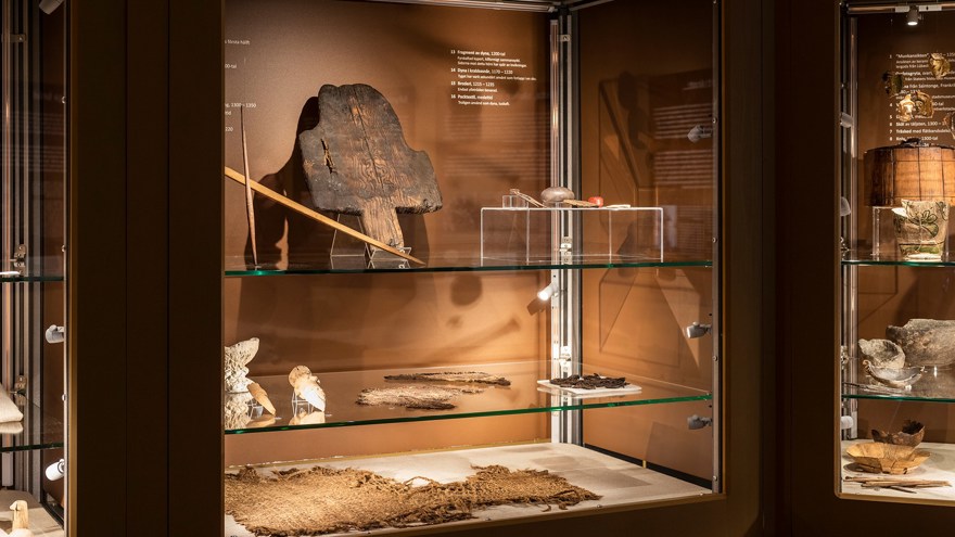 På bilden syns en monter med föremål. Färgen i montern är ljusbrun.