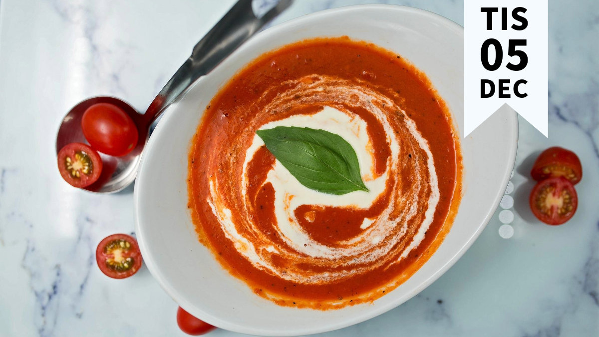 En skål tomatsoppa fotad ovanifrån med tomater spridda runtomkring