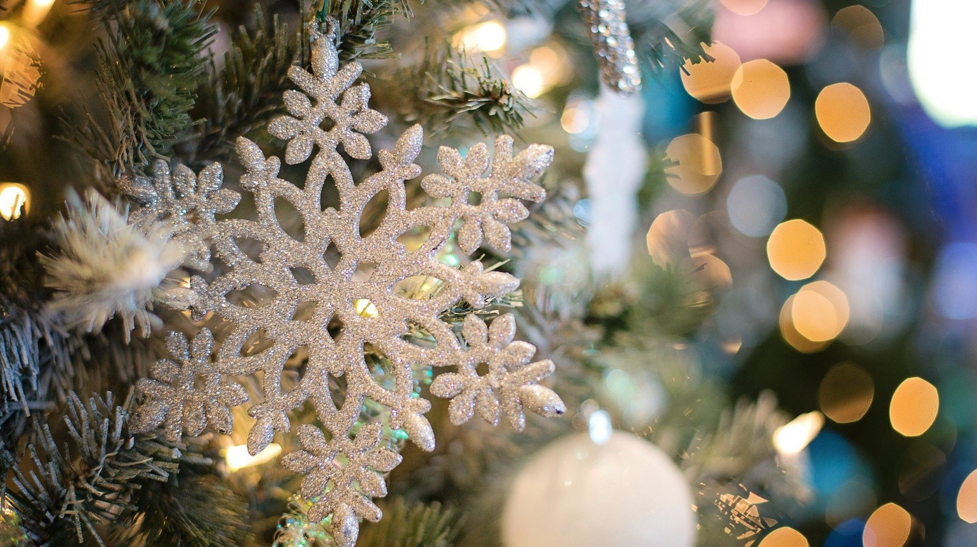 en närbild på en vit snöflinga som hänger i en julgran