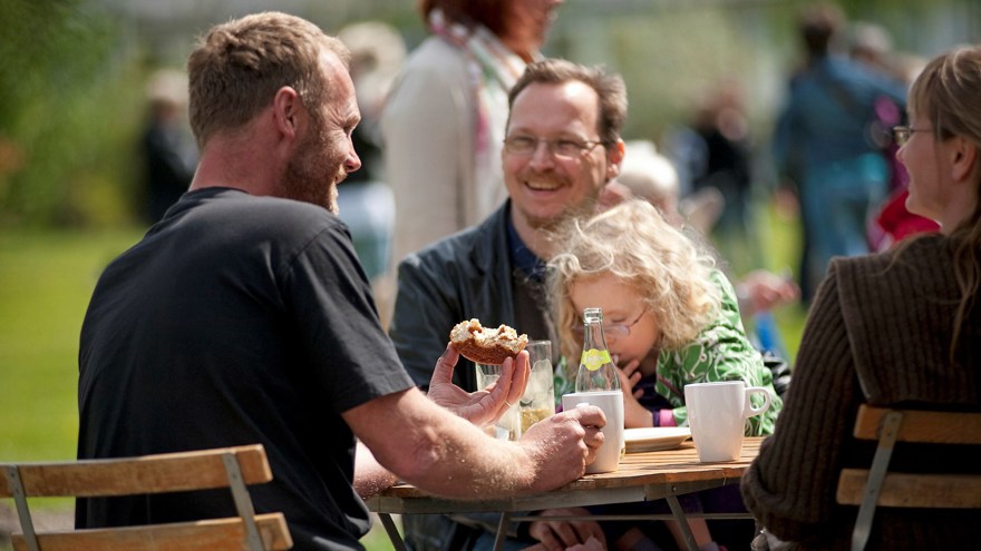 Glada människor sitter och fikar