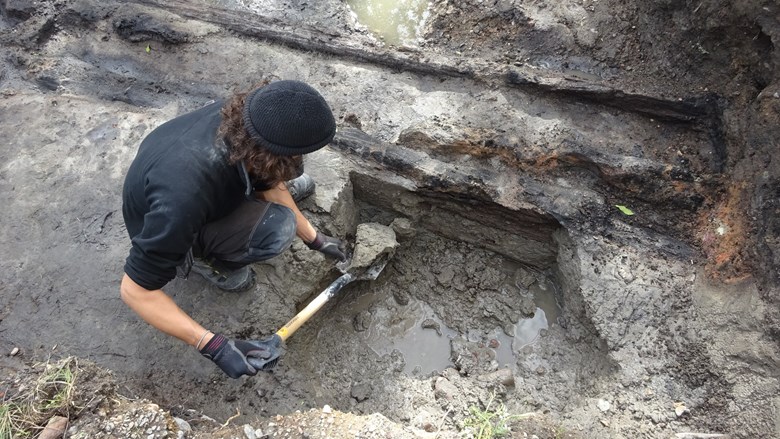 Arkeolog gräver vid en arkeologisk utgrävning