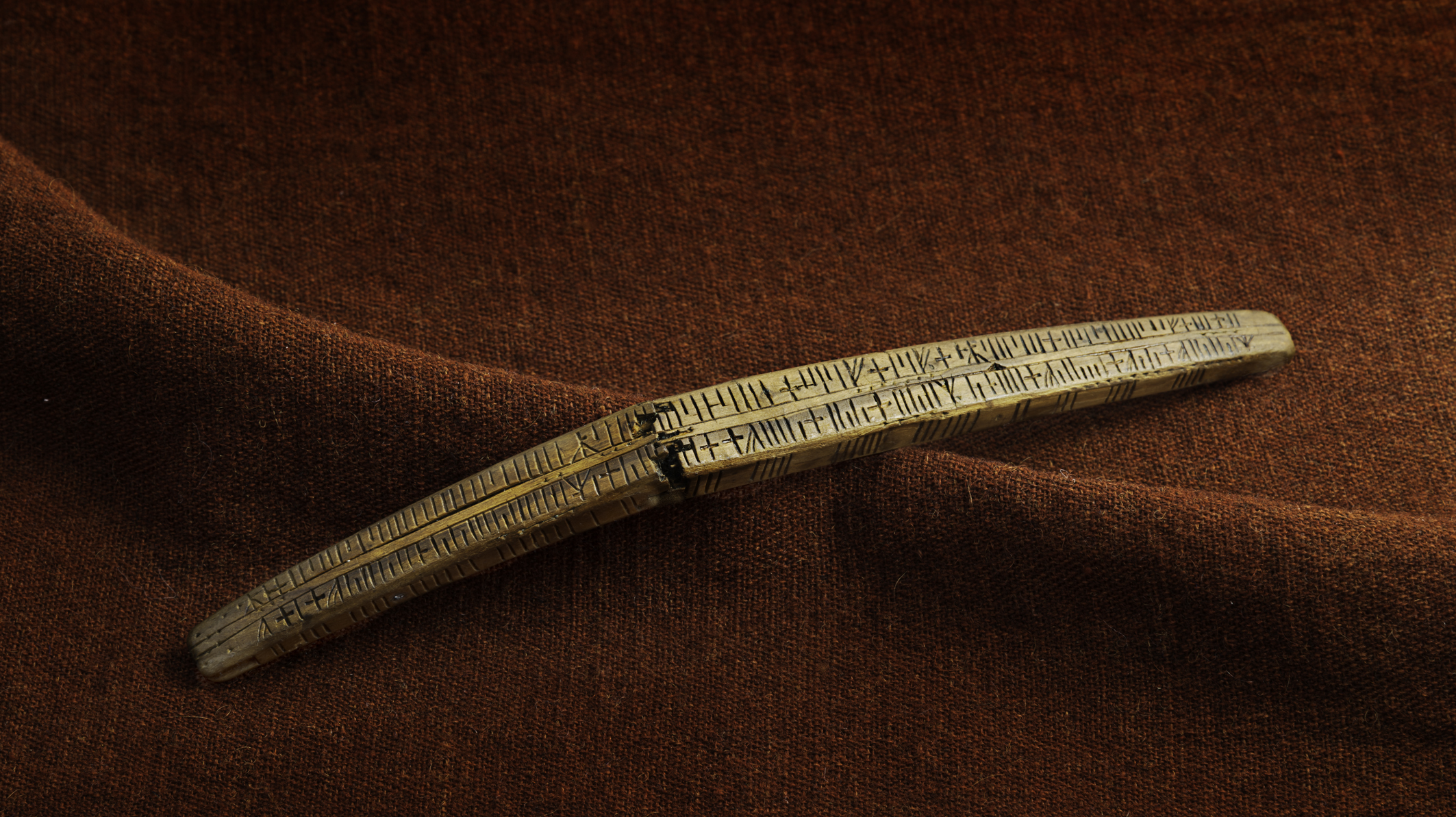 En kalendersticka i trä från medeltida med skrift.