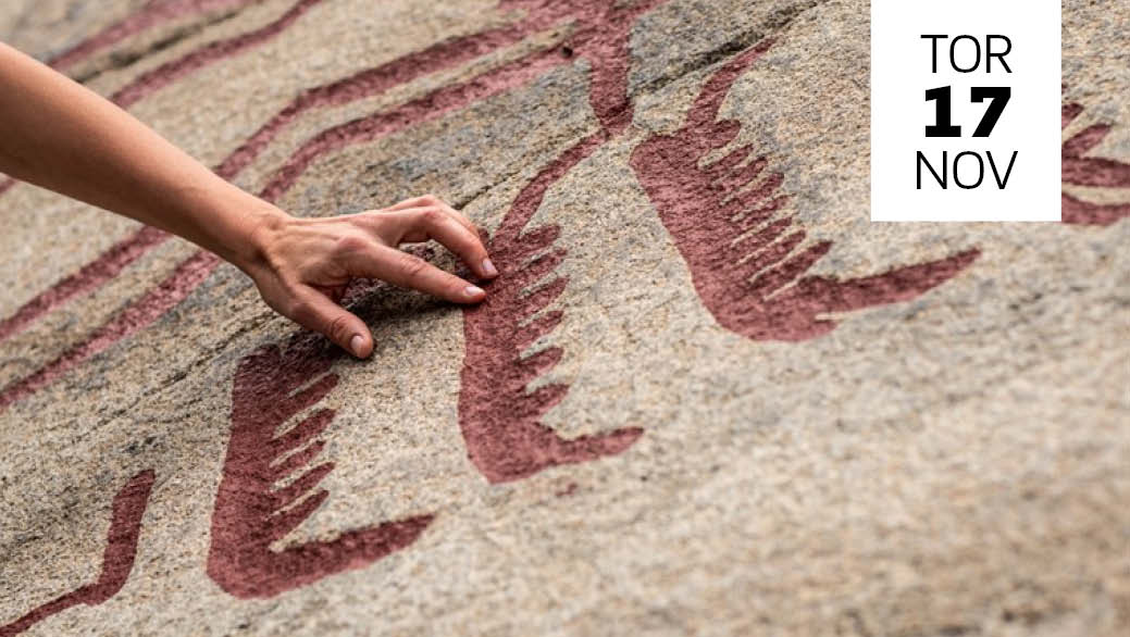 En hand vidrör hällristningar