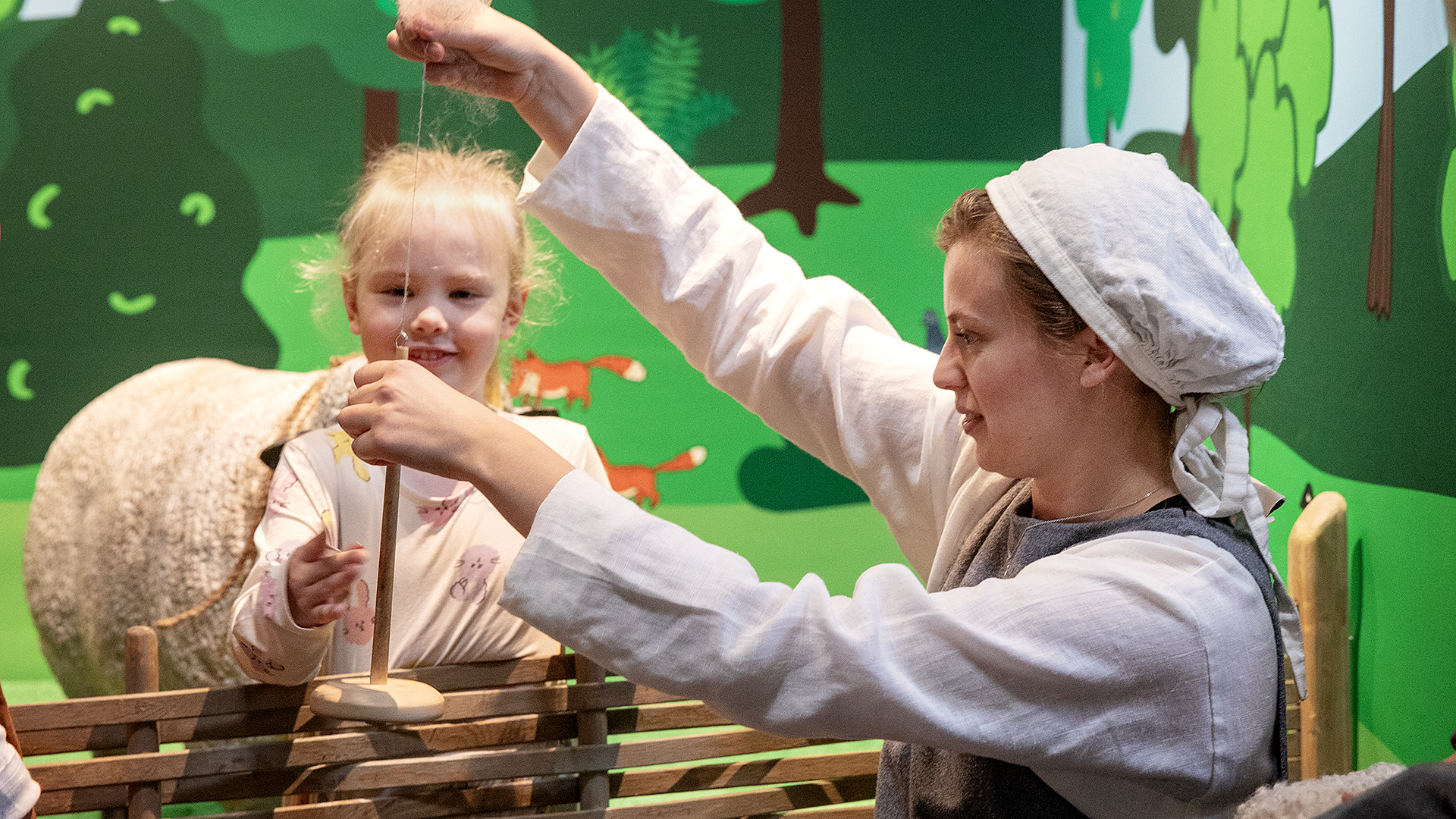 En museipedagog visar en slända för ett barn