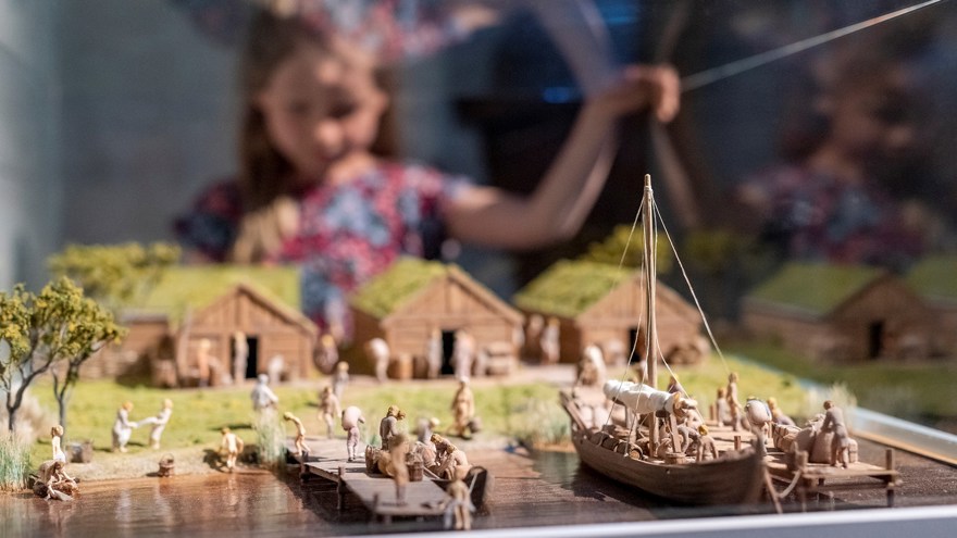 En modell av en hamn med ett suddigt barn i barkgrunden