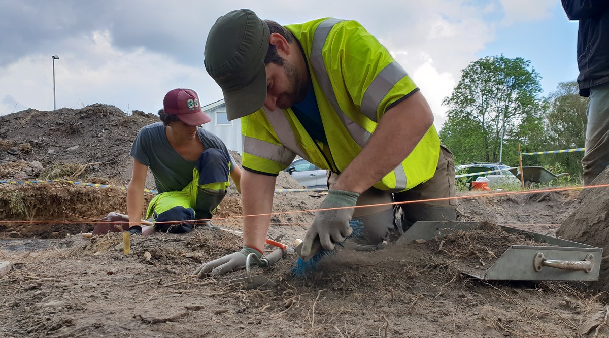 Två arkeologer gräver under en arkeologisk utgrävning