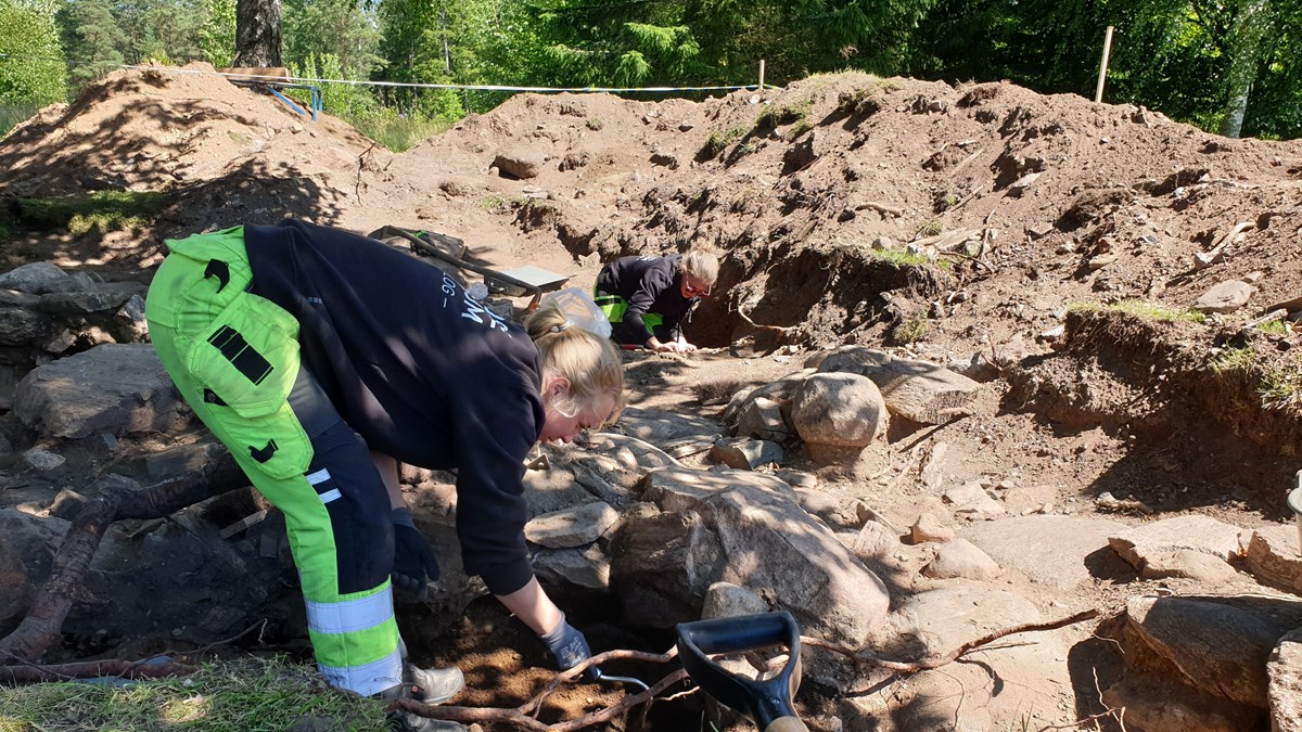 Två arkeologer gräver i en ruin
